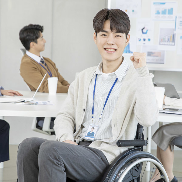 (사)장애인활동지원사업 관한 이미지로 휠체어를 탄 청년이 앉아서 응원하고 있는 이미지