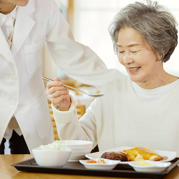 무상급식 지원사업 관련 이미지로 백발의 여성 노인이 급식을 먹고 있는 이미지